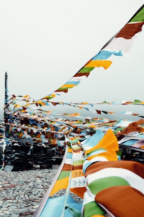 A serene Bhutanese mountain landscape with a traveler admiring prayer flags fluttering in the breeze.