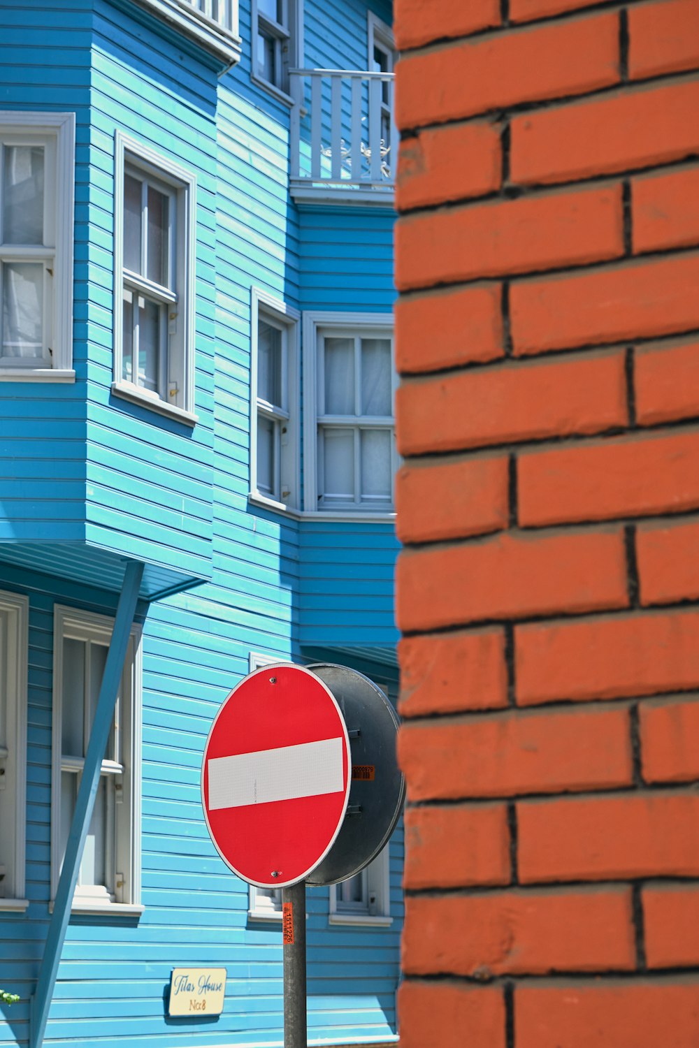 um sinal de parada vermelho sentado ao lado de um prédio azul