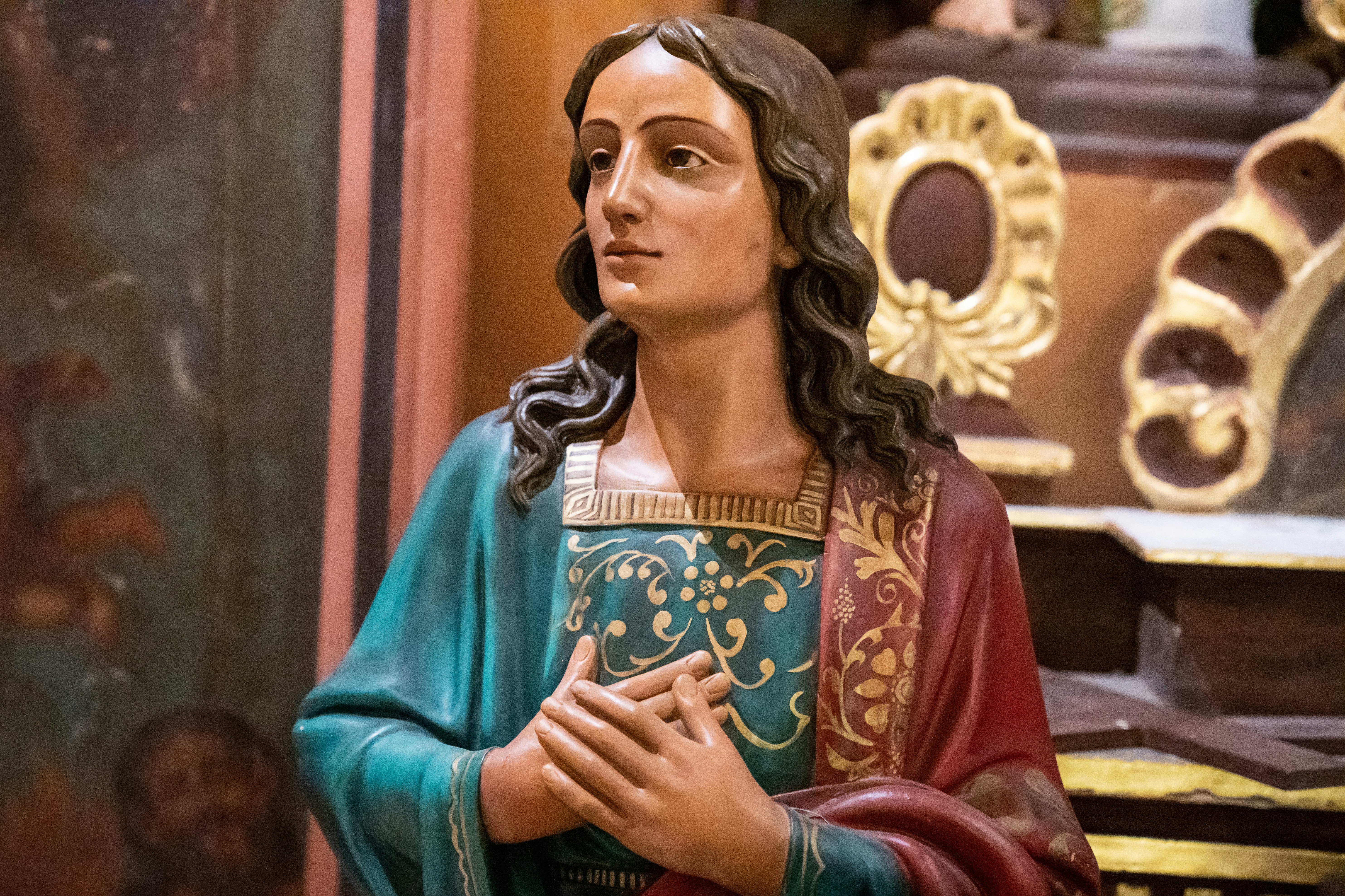 a statue of jesus holding his hands together