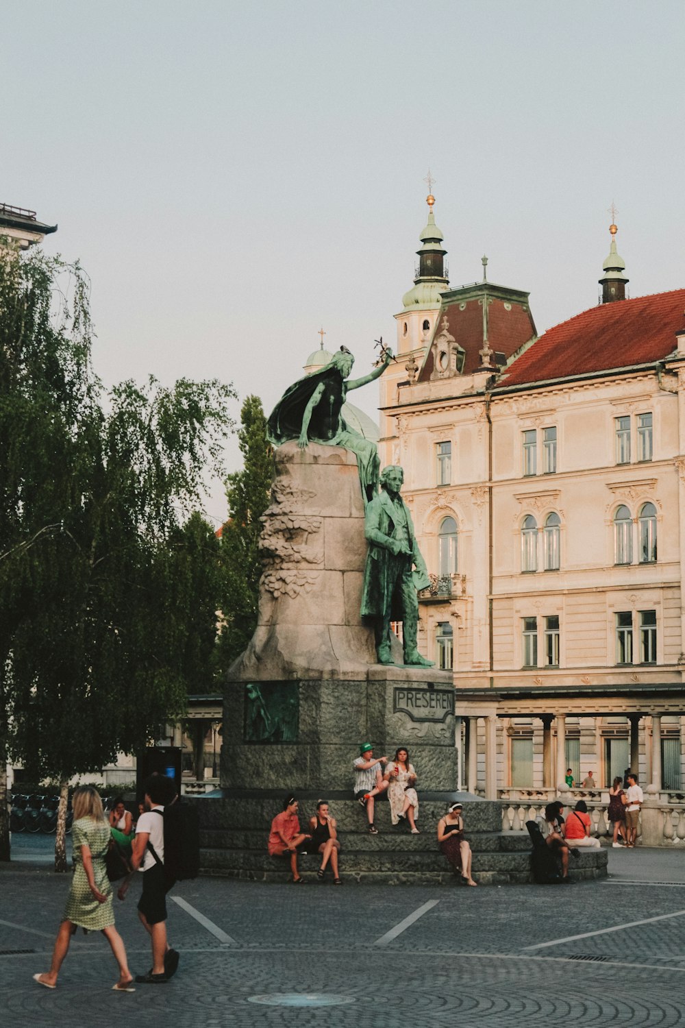 a group of people sitting on a bench in front of a building