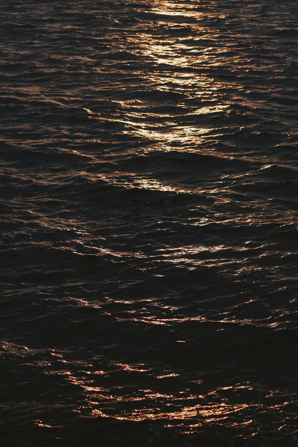 a large body of water with a boat in the distance