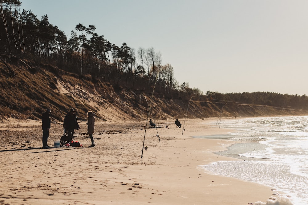 a group of people standing on top of a sandy beach