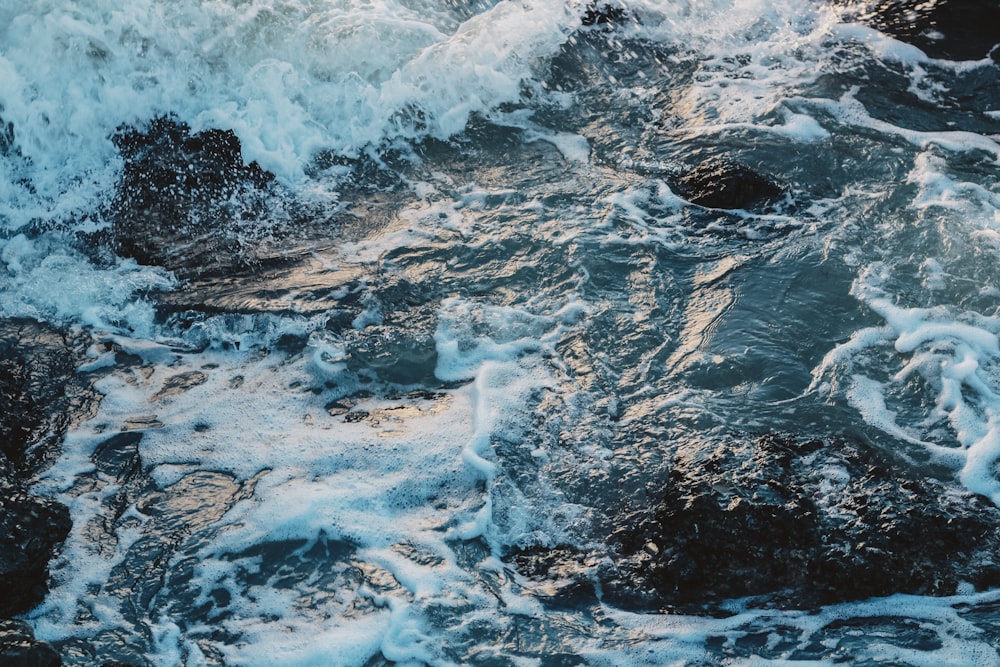 a close up of waves crashing on rocks