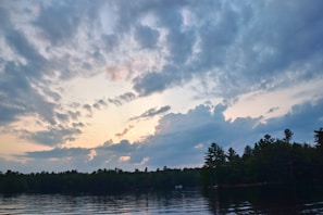 A serene lake at sunrise reflecting the soft colors of dawn.