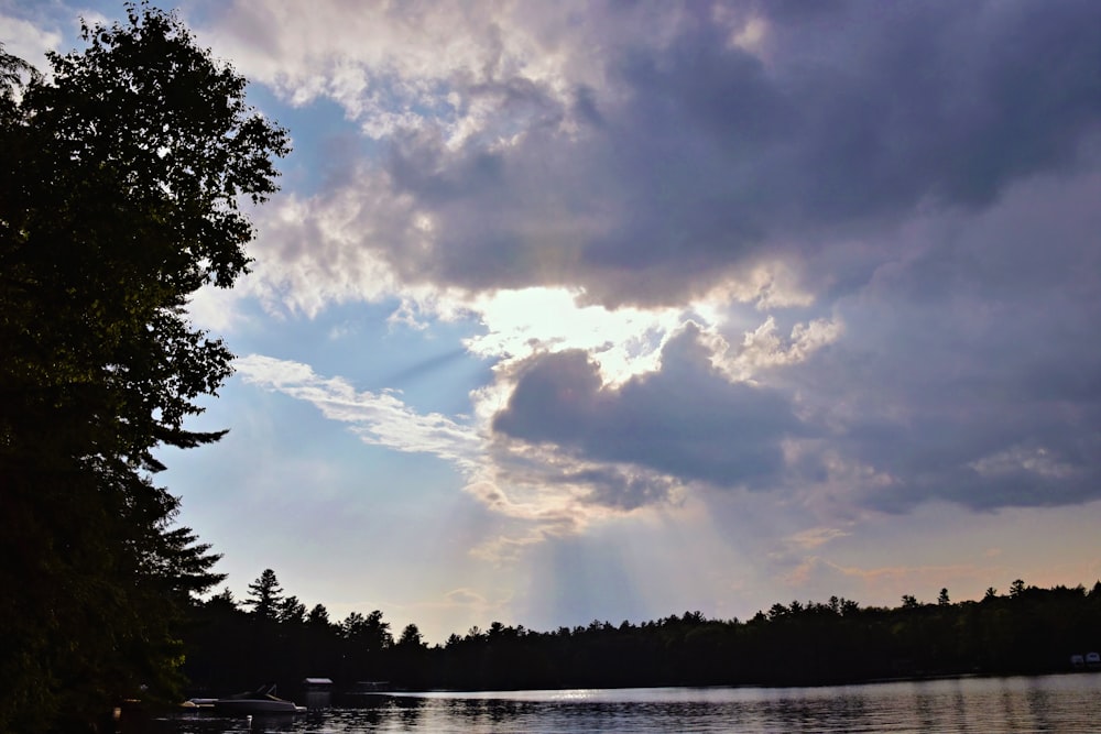 the sun is shining through the clouds over the water