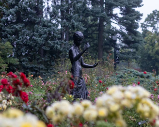 Portrait of Déborah Bourgeois standing peacefully in a sunlit garden, symbolizing hope and renewal.