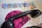 A cut-out collage with colorful letters forming the word 'CREATIVE' is placed on top of a page of text. A black telephone handset rests on a vibrant, pink fabric featuring a black, leopard-like print. Underneath are lace doilies.
