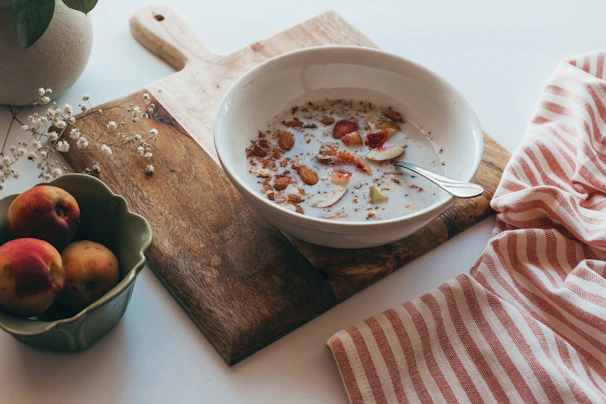 A serene breakfast scene with éclat de table white ceramic bowls filled with fresh fruit.