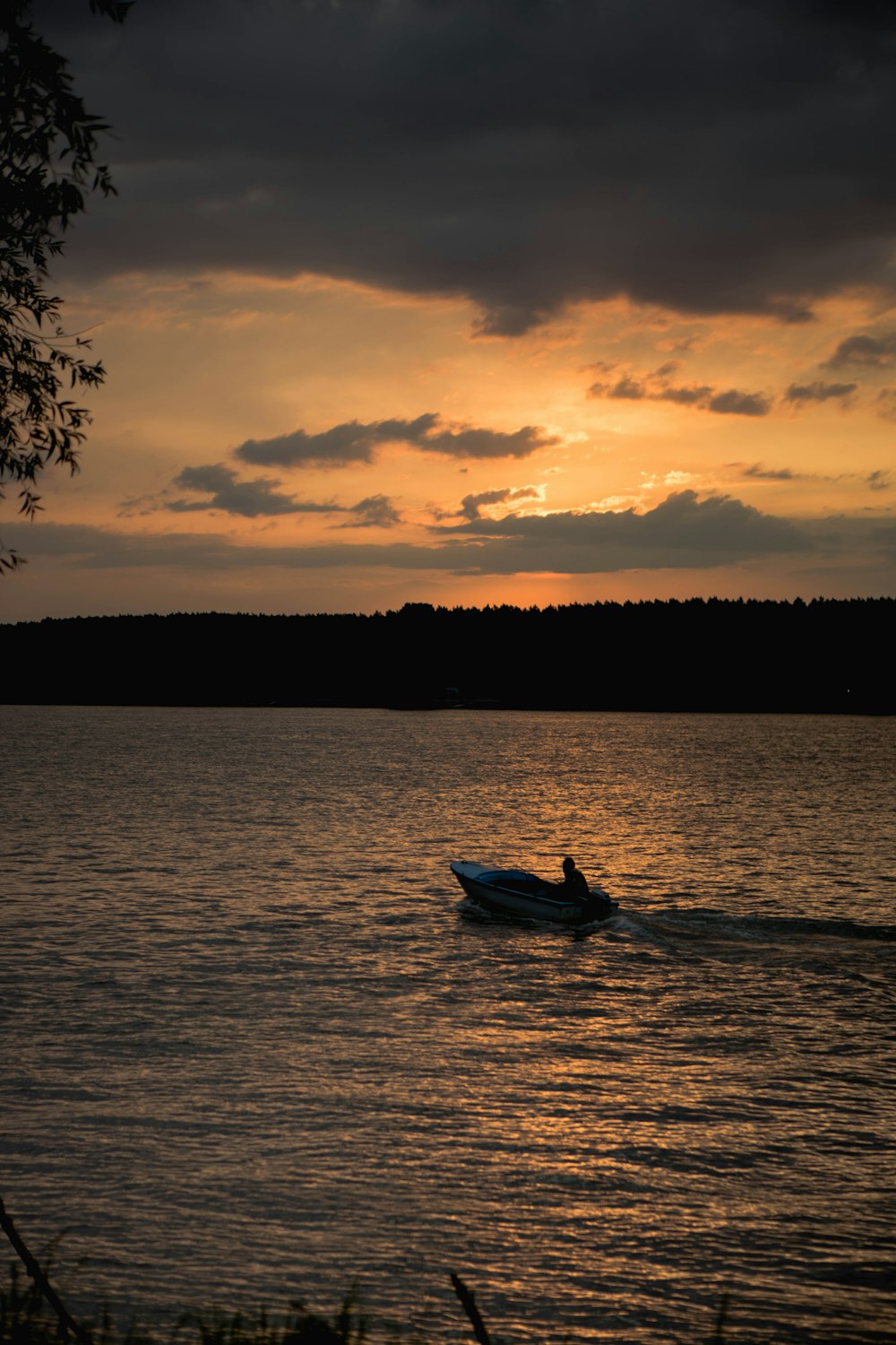 a person on a boat in the water at sunset