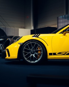 A sleek yellow car with spinning wheels on a dark gray background.