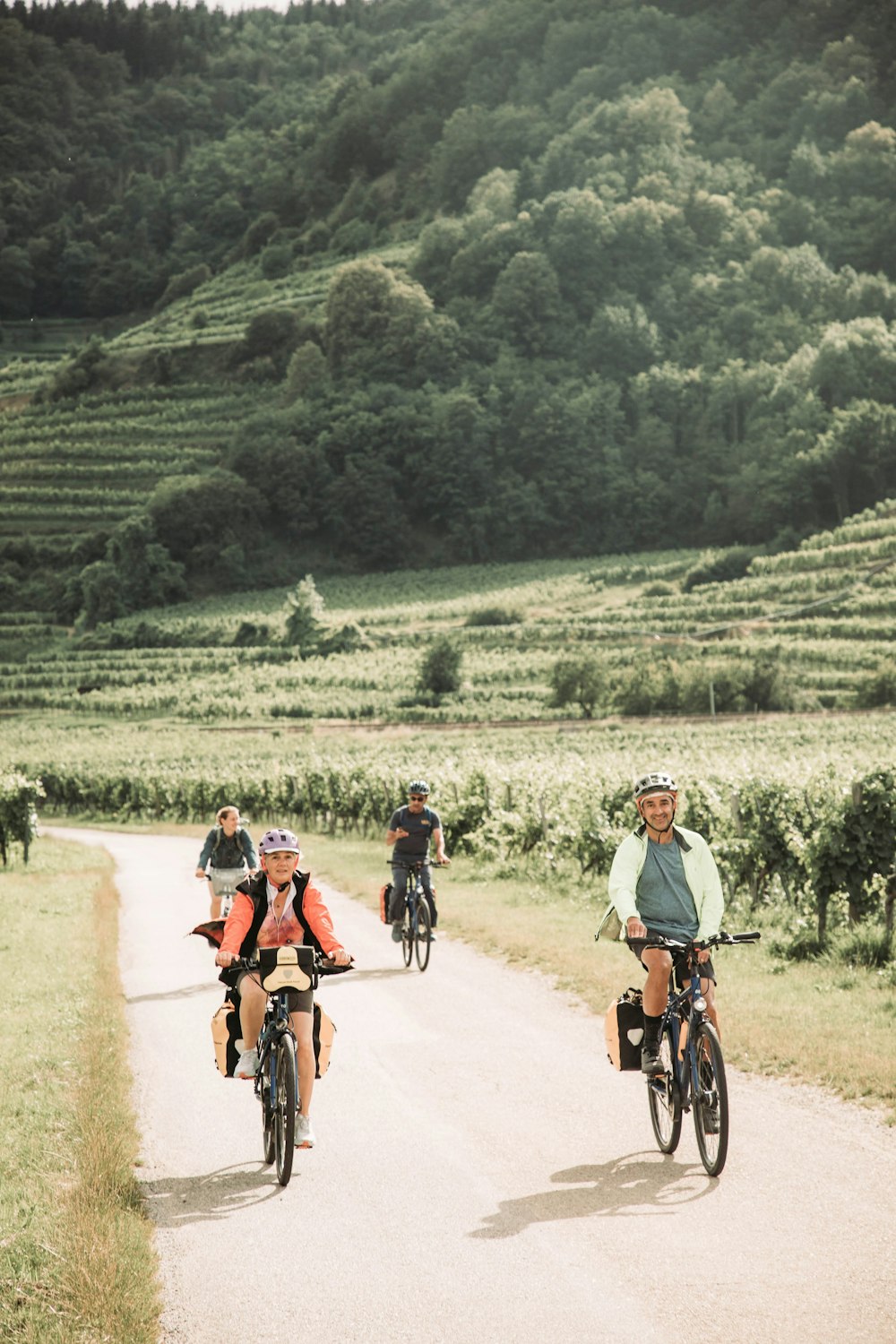 a group of people riding bikes down a dirt road