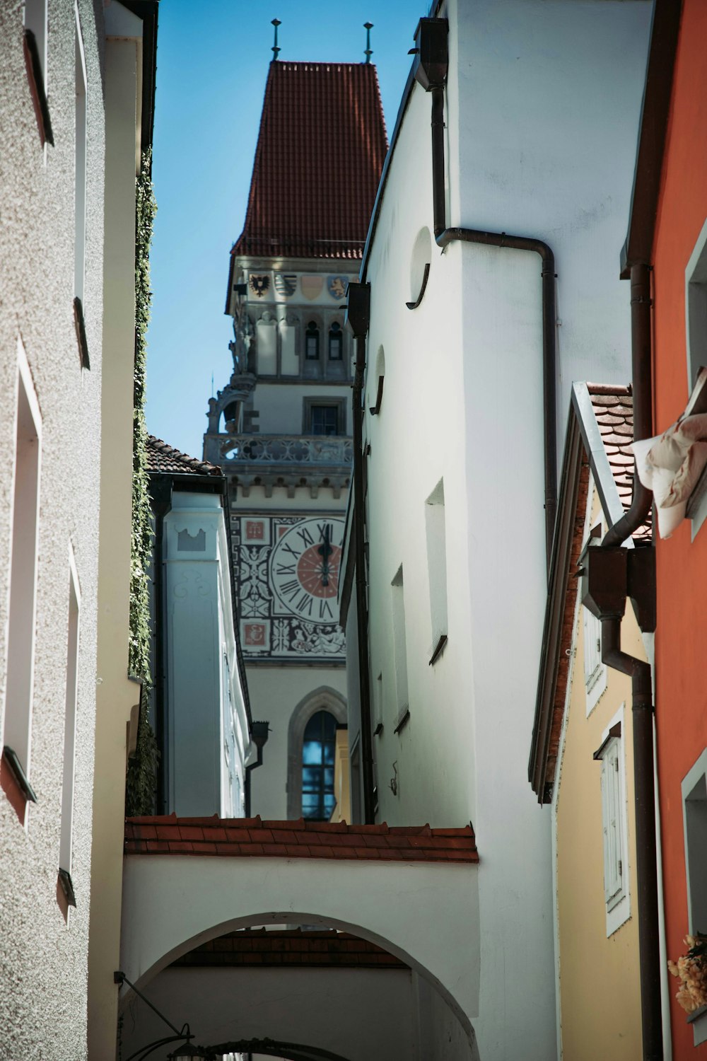 a narrow alley with a clock tower in the background