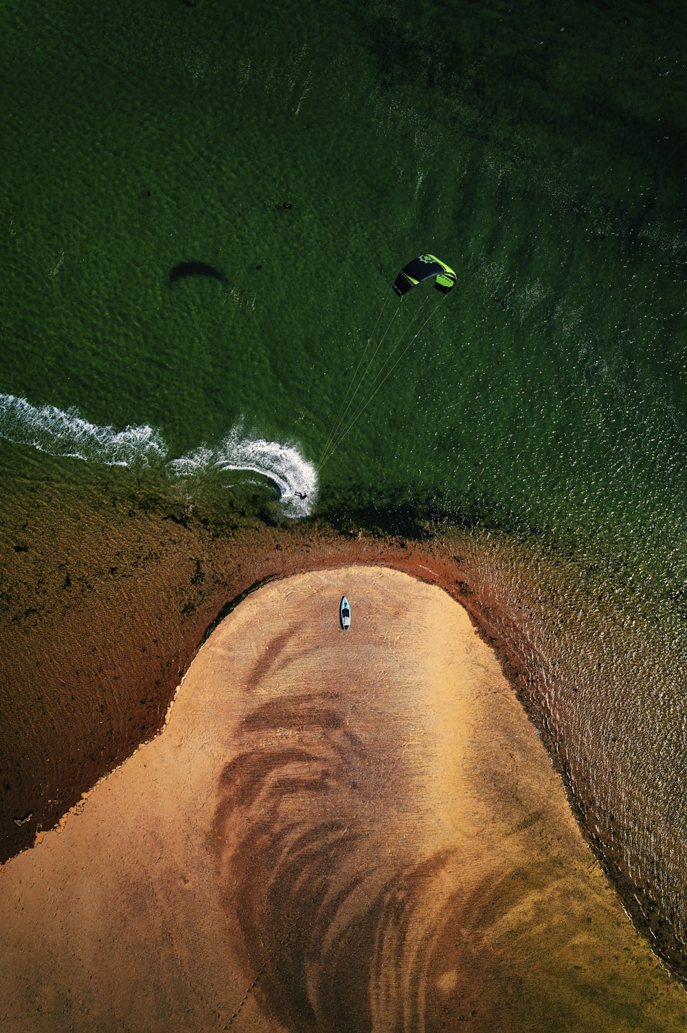 an aerial view of a person parasailing in the ocean