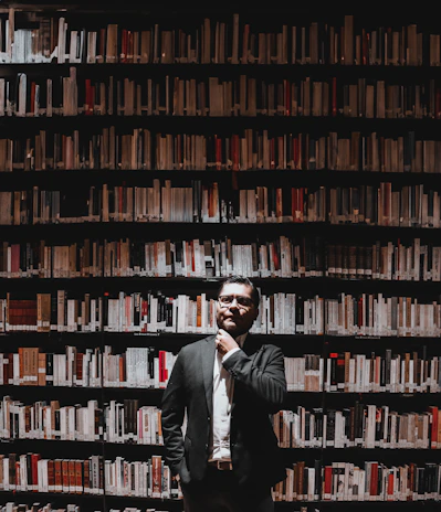 A thoughtful scholar studying ancient political manuscripts in a warmly lit library.