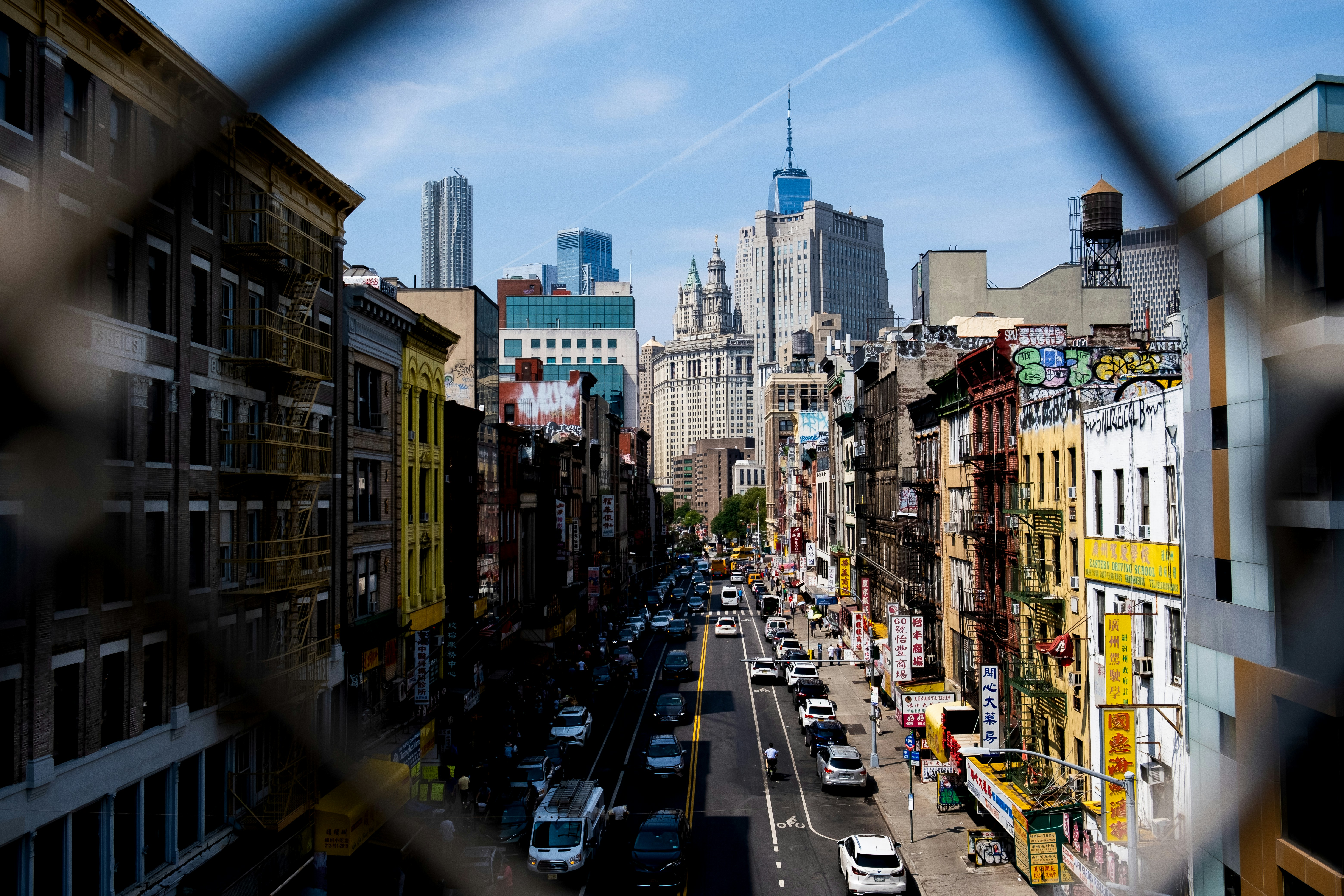 A view of a city street through a chain link fence photo – Free Car ...