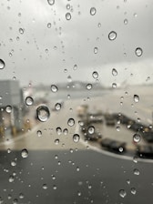 Stormy weather outside airport window causing flight disruptions.