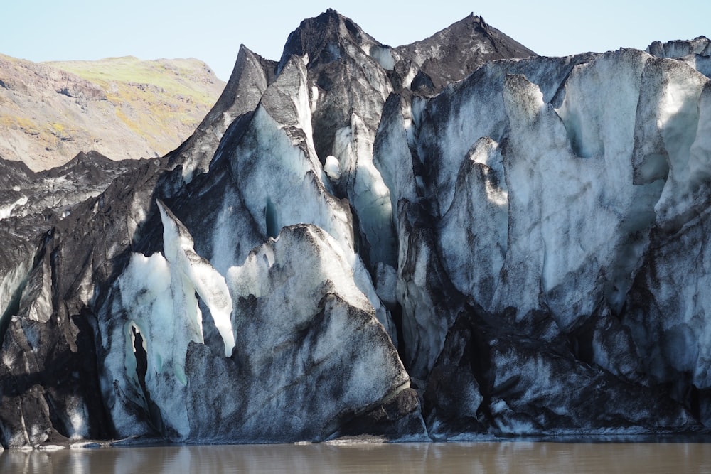 a group of large rocks sitting next to a body of water