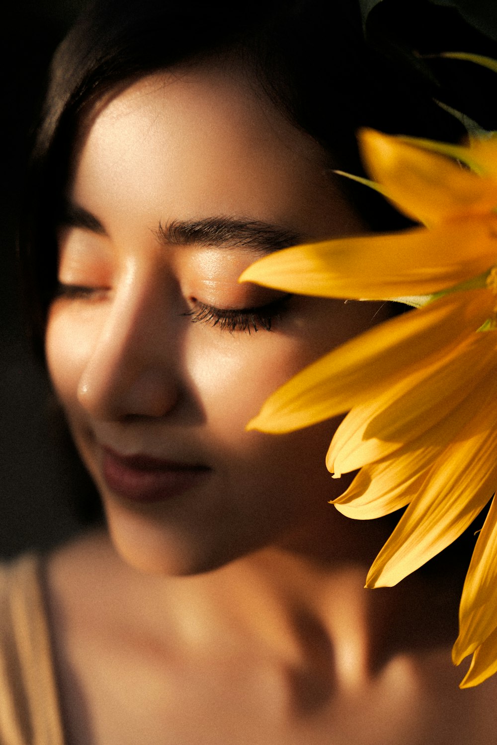 a woman is holding a sunflower in her hand