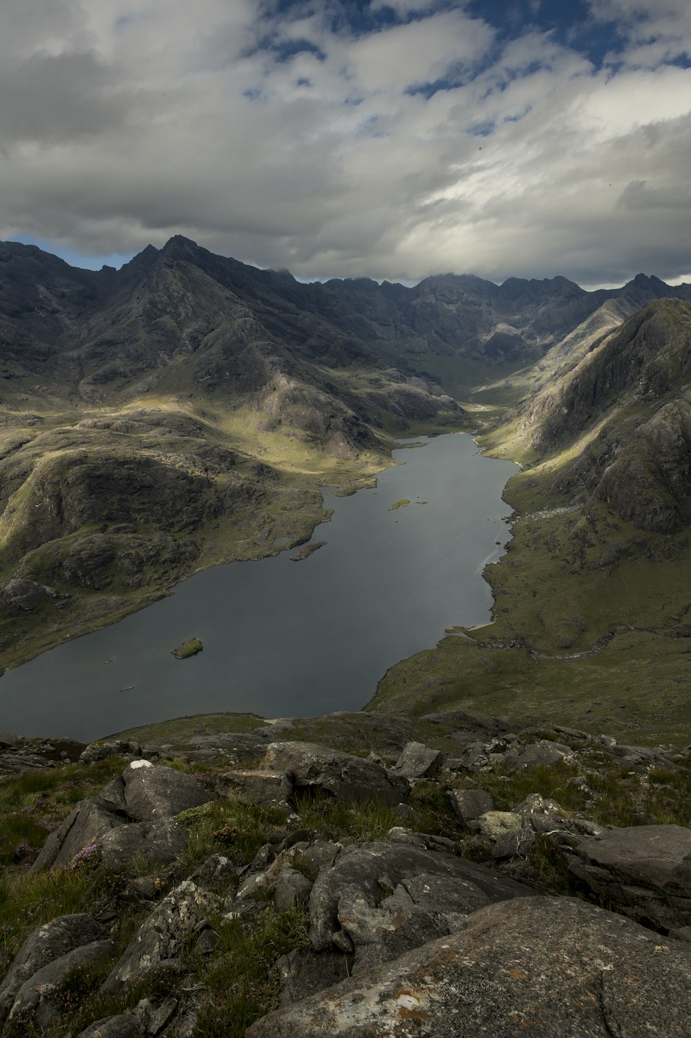 um lago cercado por montanhas sob um céu nublado