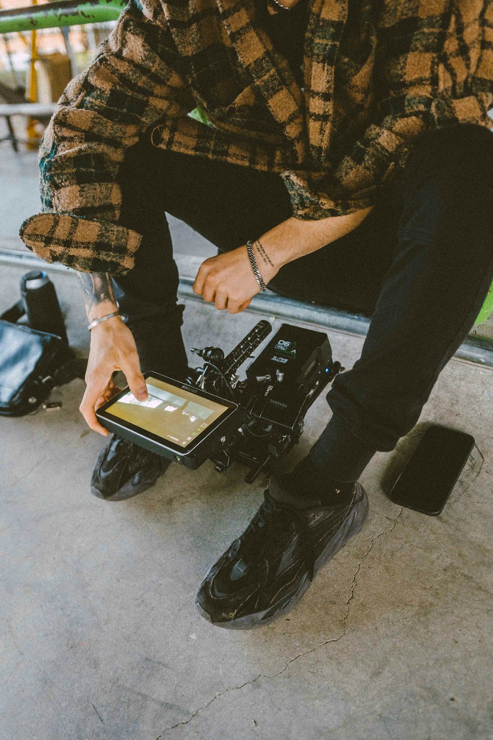 a man sitting on the ground holding a tablet