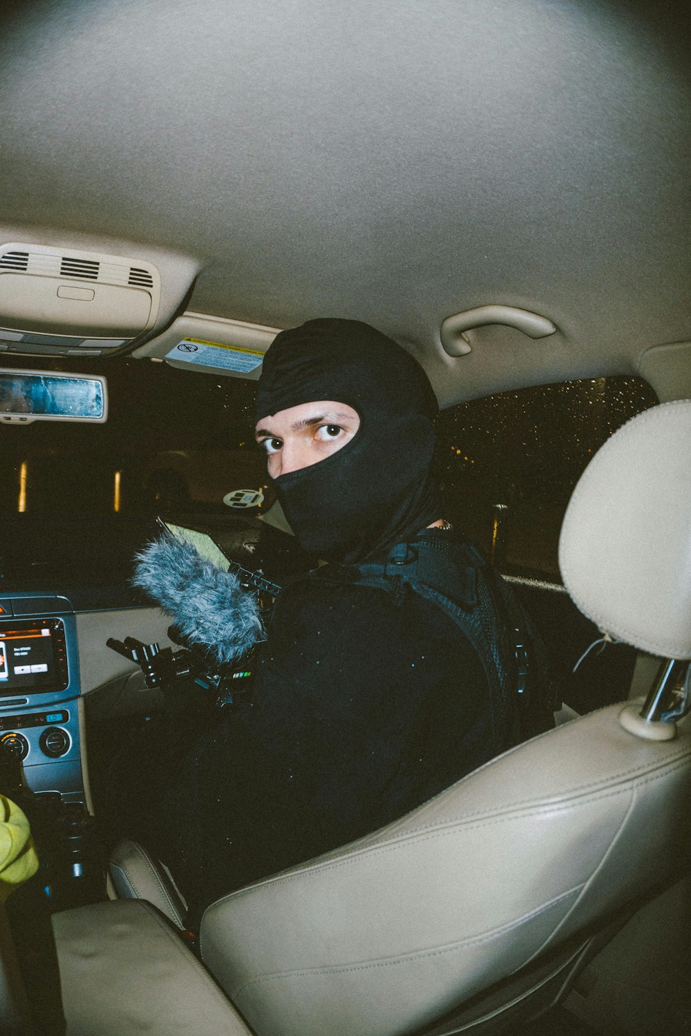 a person in a car wearing a black mask