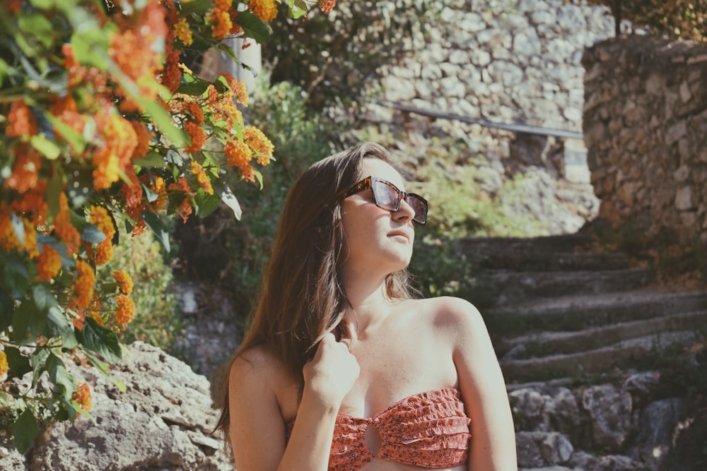 a woman wearing a bikini top and sunglasses