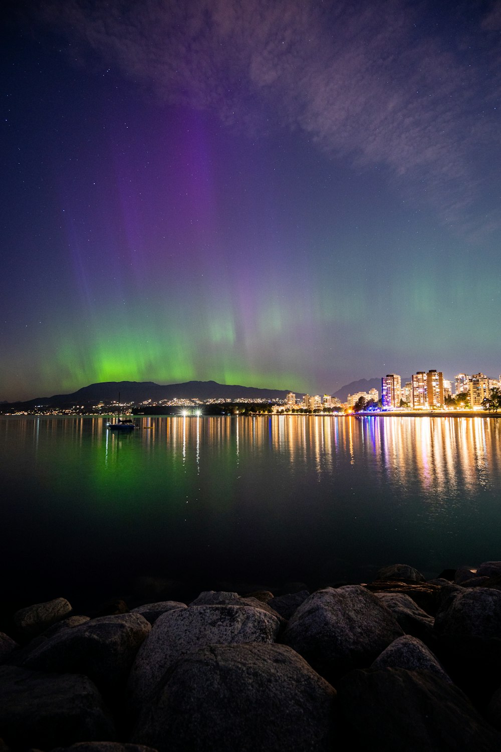 Ein Polarlicht bohrte sich über eine Stadt und ein Gewässer