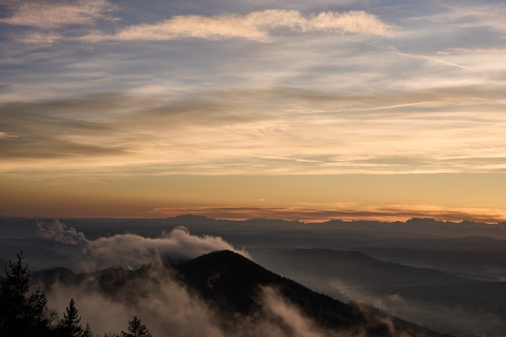 the sun is setting over a mountain range