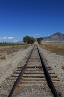 A high-speed railway track stretching into the horizon under a clear blue sky.