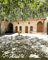 The sun-dappled courtyard of Torre Palazzone, with terracotta pots and blooming greenery inviting quiet moments.