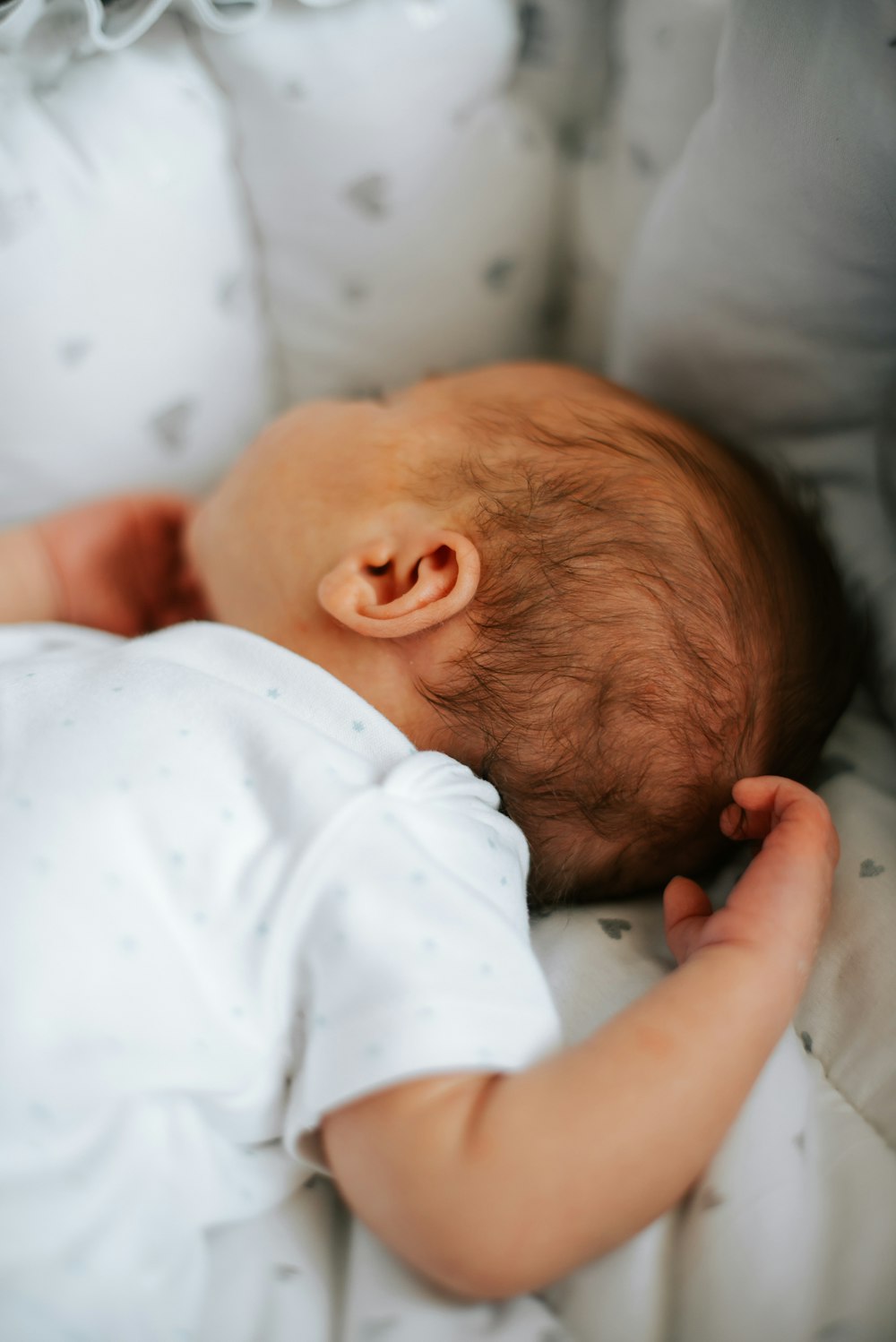 Ein Baby schläft in einem weißen Kinderbett