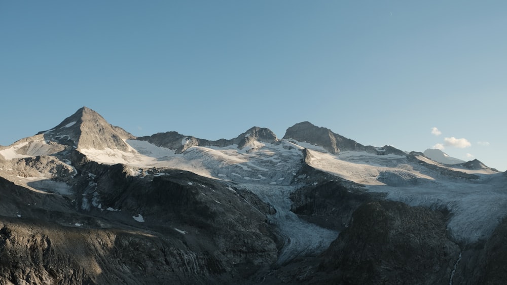 a mountain range with snow covered mountains in the background