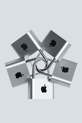 Multiple silver padlocks are interconnected, each displaying a prominent logo in black on the front surface. The locks are arranged in a symmetrical, radial pattern against a pale background.