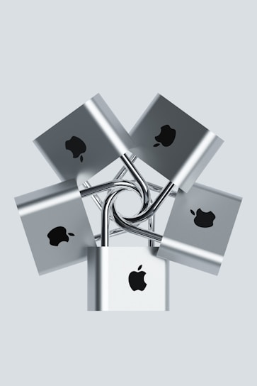 Multiple silver padlocks are interconnected, each displaying a prominent logo in black on the front surface. The locks are arranged in a symmetrical, radial pattern against a pale background.