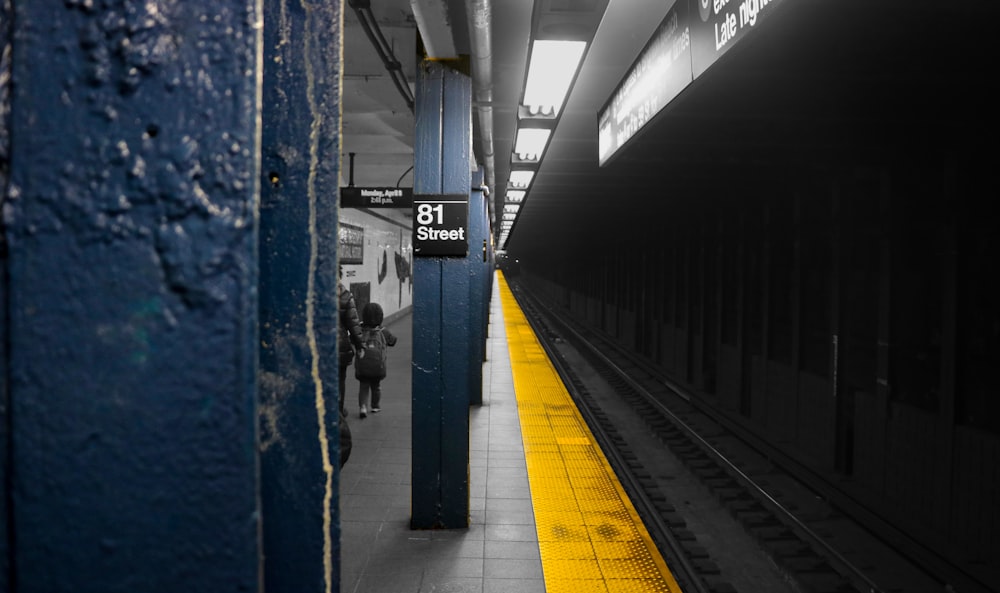 a train station with a yellow line on the platform