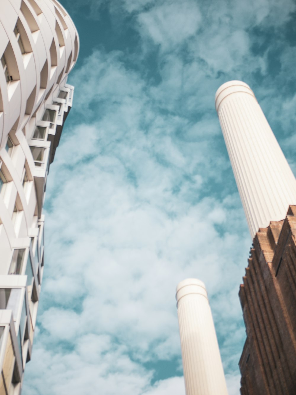 two tall white buildings with a blue sky in the background