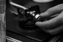 Close-up of hands adjusting a Summa plotter's cutting blade with precision.