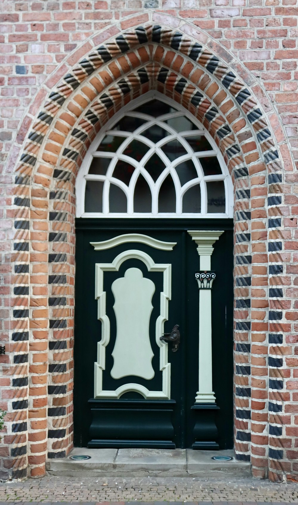 a black and white door with arched glass