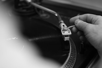 Close-up of a hand carefully sliding a vinyl record out of its sleeve.