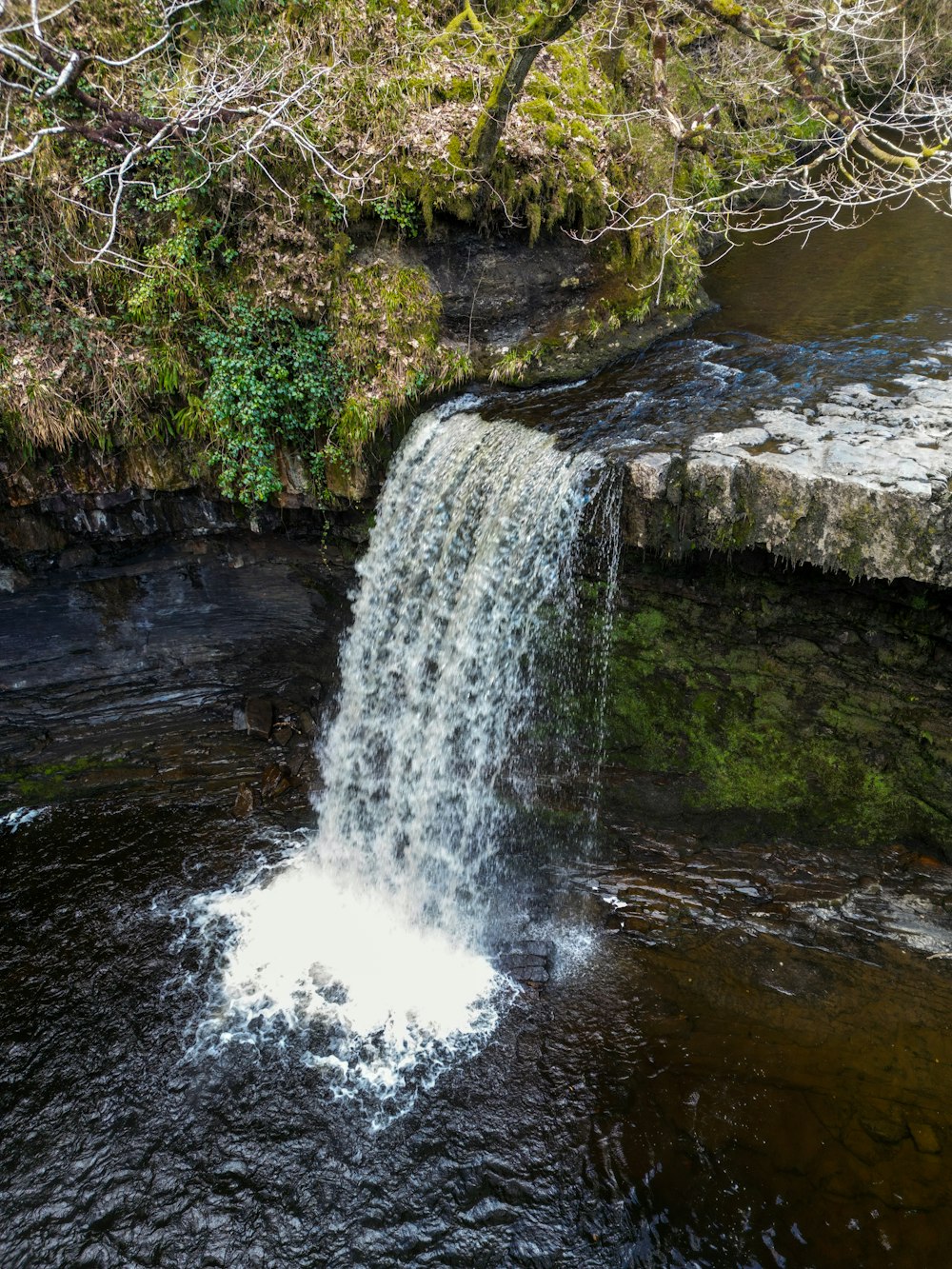 a small waterfall with water cascading over it