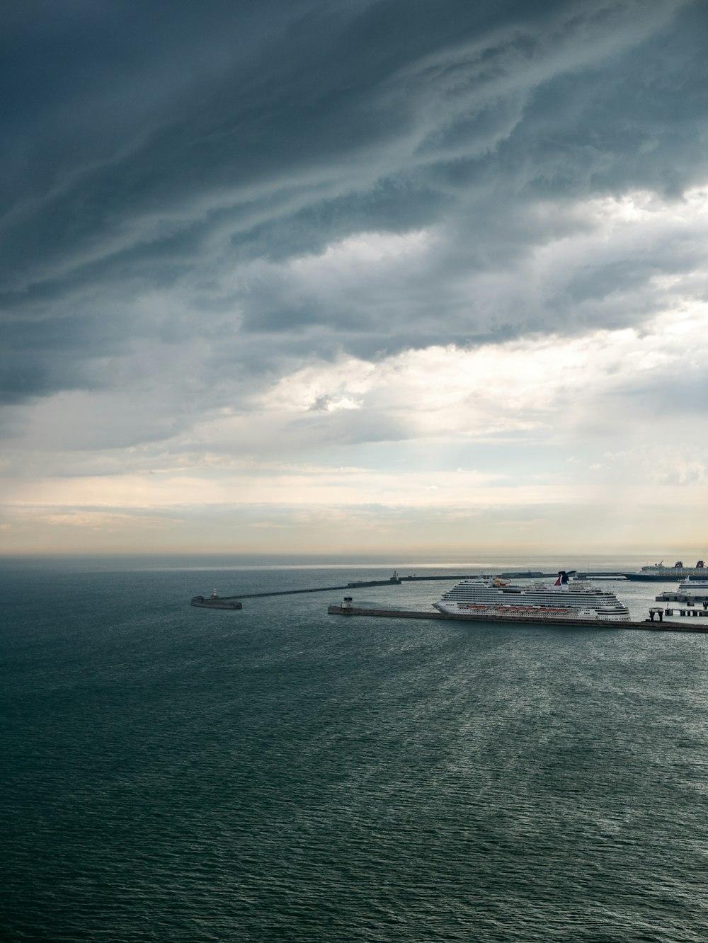 a large cruise ship in the ocean under a cloudy sky