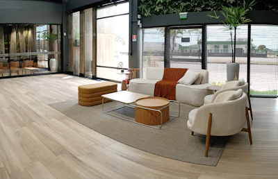 A modern, minimalist living room featuring Jara Teak furniture pieces bathed in natural light.