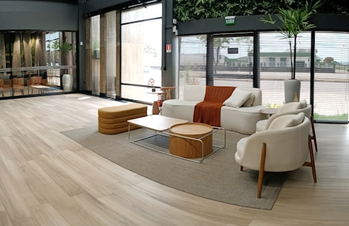 A modern living room featuring minimalist furniture and large windows.