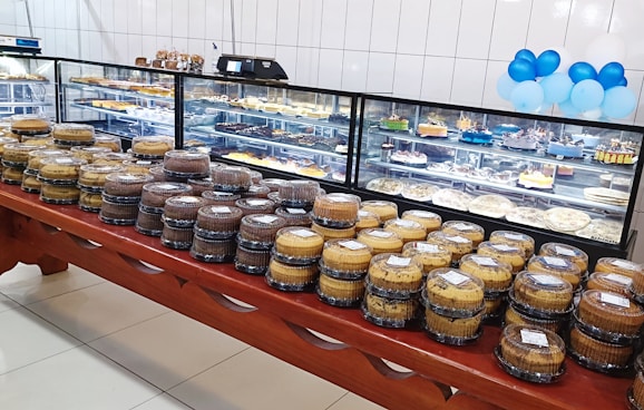 A colorful assortment of traditional Slovak cakes arranged neatly on a rustic wooden table by the river.