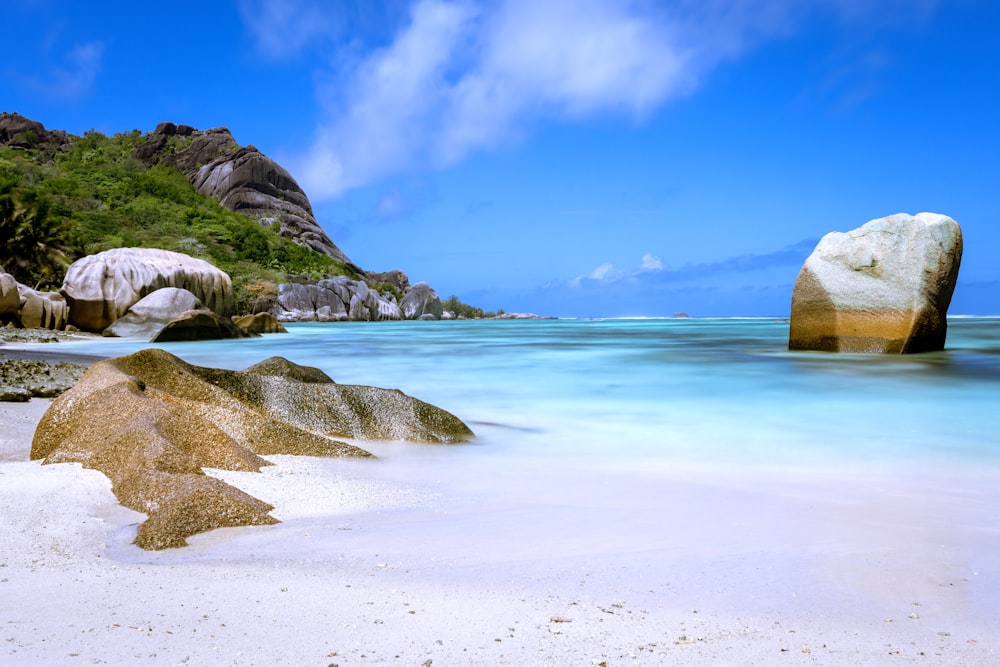 a large rock sitting on top of a sandy beach