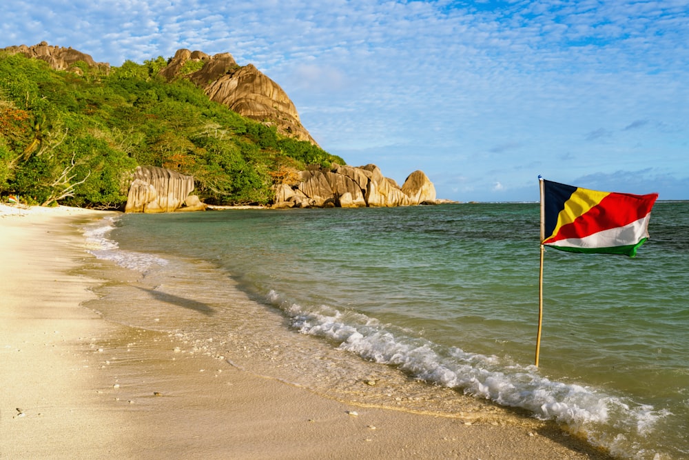 a flag on a beach next to the ocean