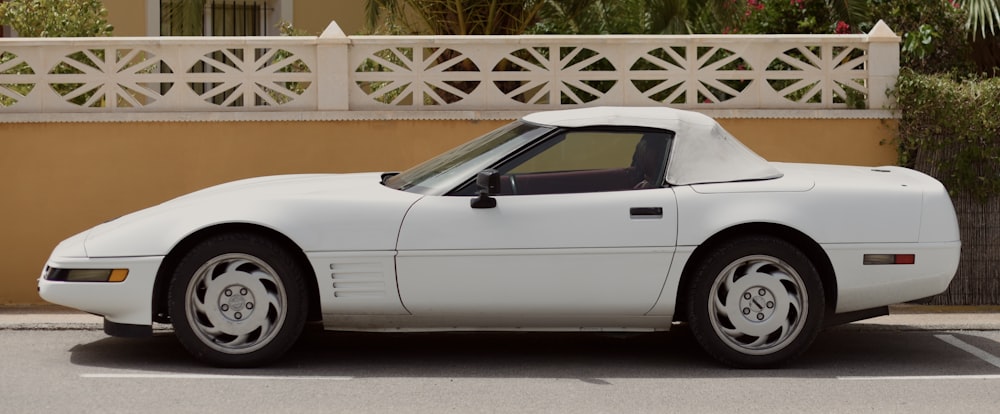 a white sports car parked in a parking lot