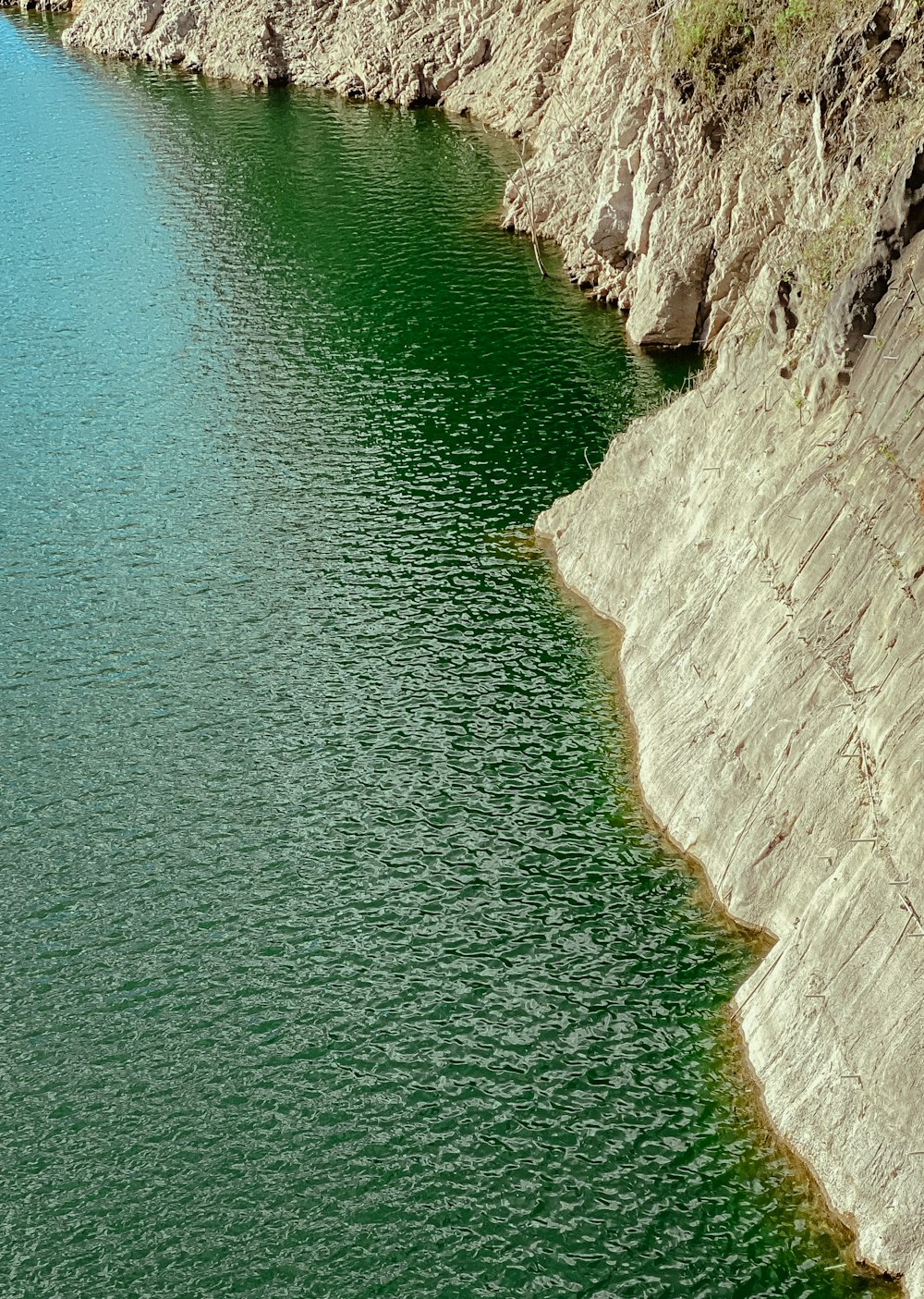 a large body of water surrounded by a rocky cliff