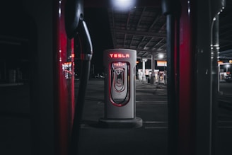 a gas pump in a parking lot at night
