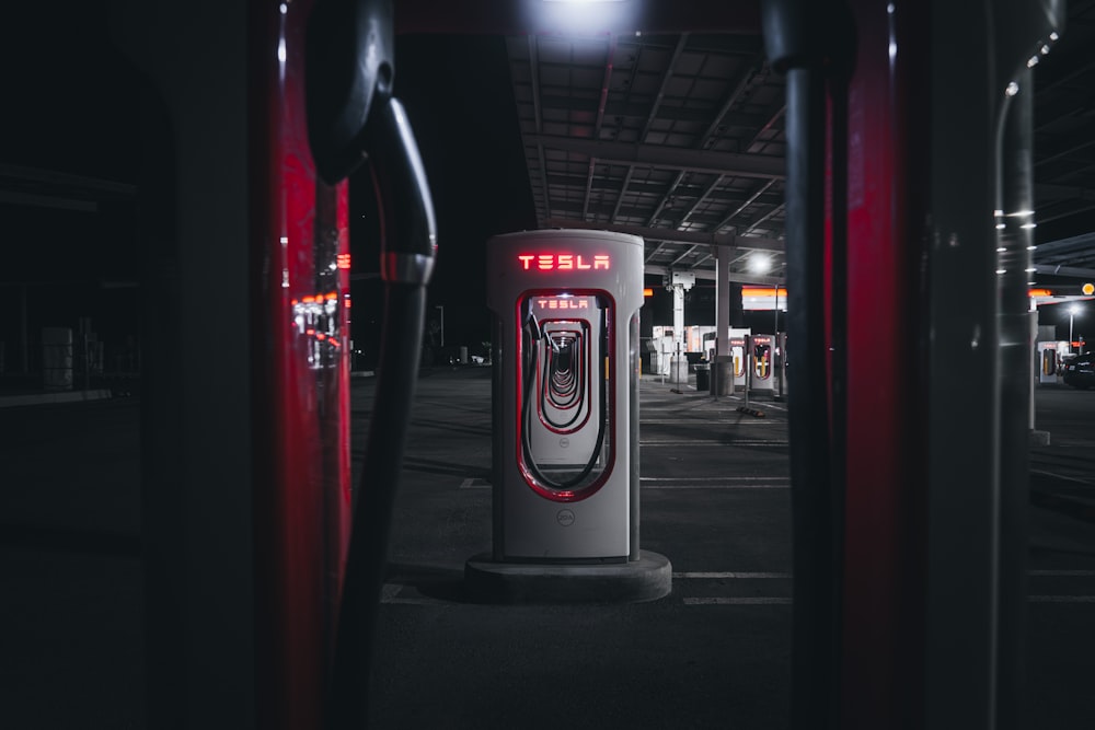 a gas pump in a parking lot at night